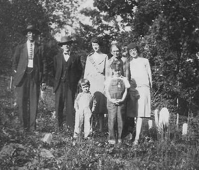 Unknown man.  Jim Ball (husband of Ossie Coates).  Elizabeth Coates (daughter of Eliza Coates).  Eliza Coates.  Ossie Ball, nee Coates (daughter of Eliza Coates).  Unknown children.  c.1933-35.
Photograph taken in the Coates Family cemetery.