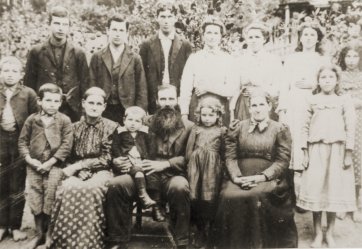 Mr Solomon Shelton, with beard, is seated in the front row holding a young boy.  Virginia Shelton is standing at the extreme right on the front row.  Donna Shelton is the girl standing on the back row next to the tall man